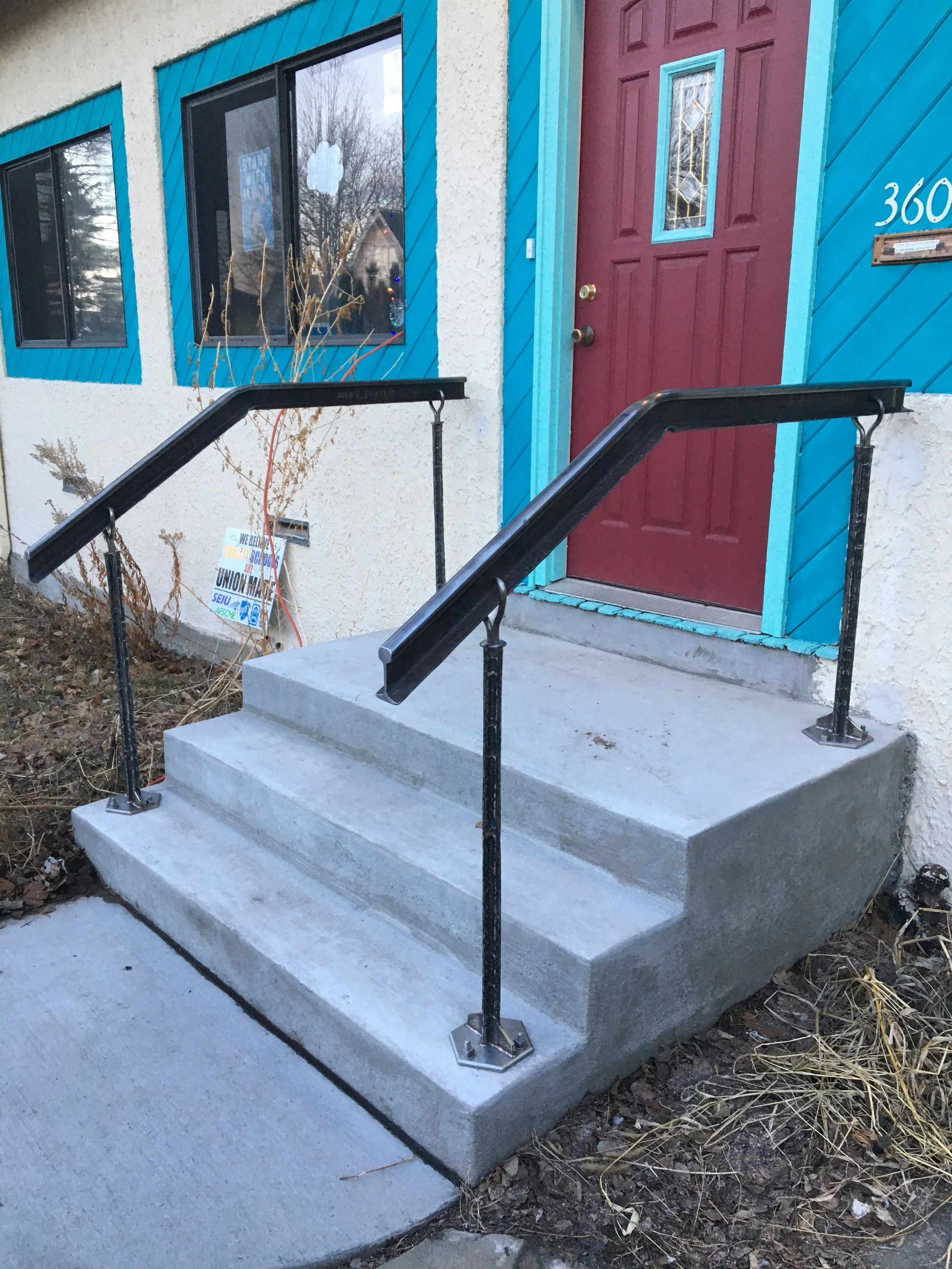Custom handrail from salvaged grain silo trolley rail.
