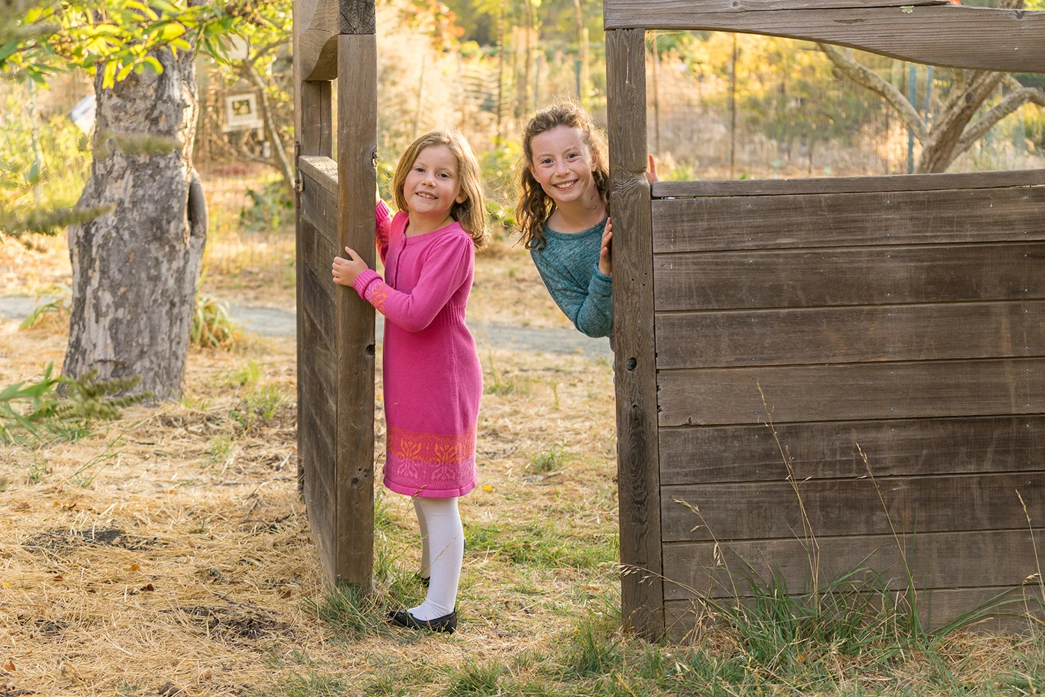 two sisters peering through the gate at Crow Canyon Gardens-San Ramon photographer