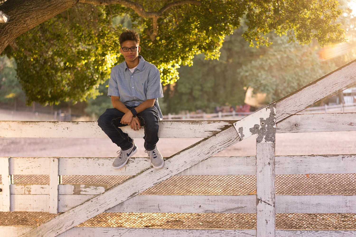 high school graduate sitting on fence-Danville outdoor photography