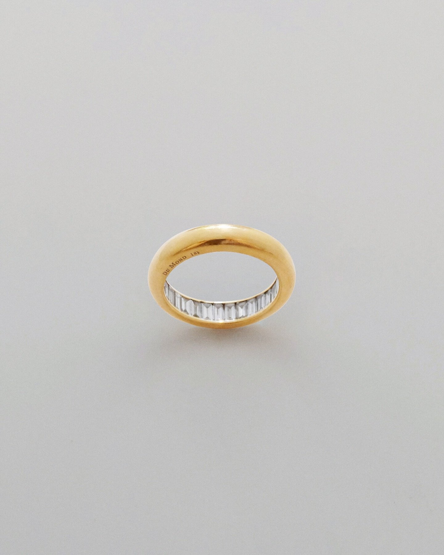 Gold band filled with baguette-cut diamonds. The interior of each ring is lined with diamonds, much like a hall of mirrors.

A portion of the proceeds from each ring goes towards a cause that benefits the earth.

A U.S. design patent has been granted