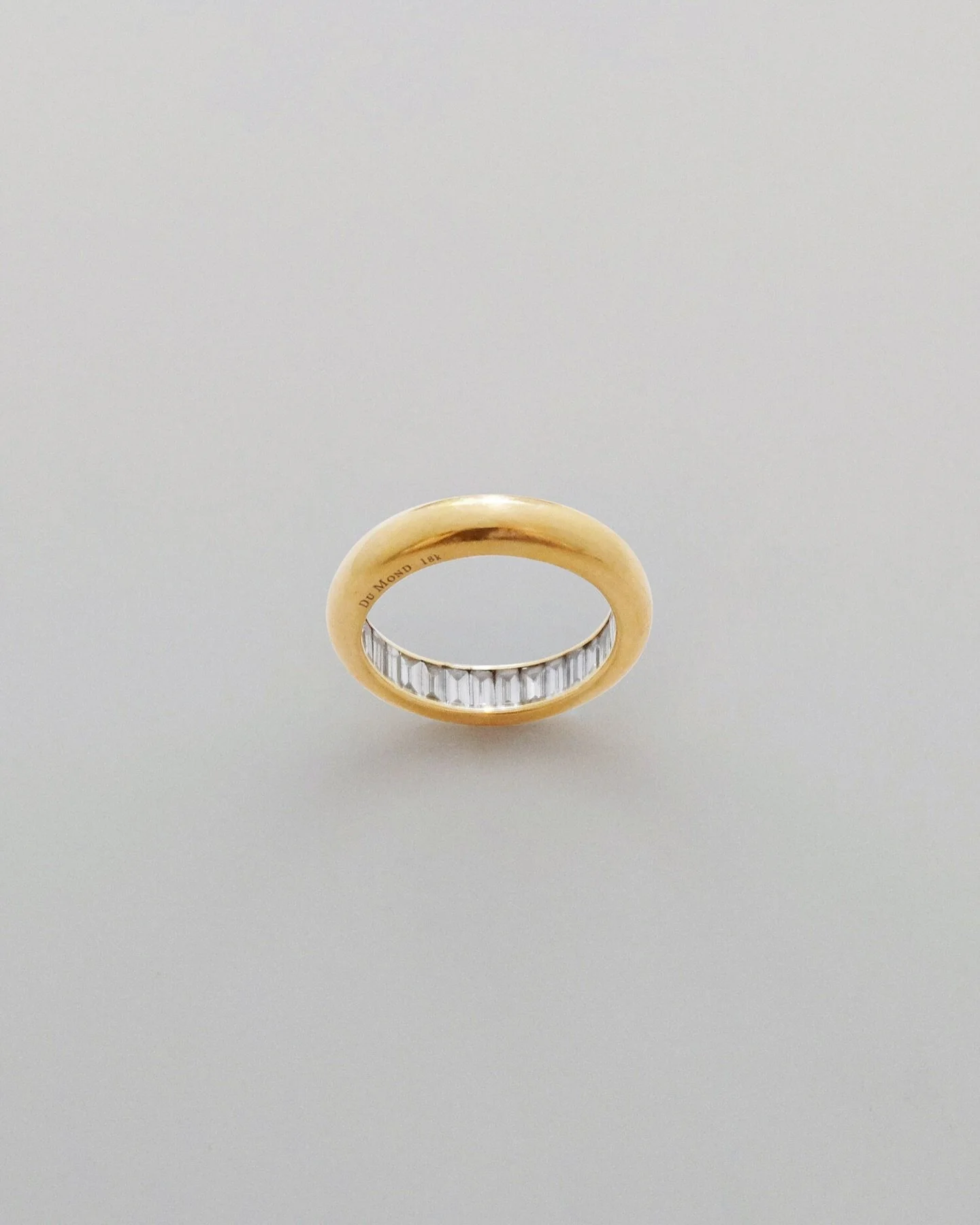 Gold band filled with baguette-cut diamonds. The interior of each ring is lined with diamonds, much like a hall of mirrors.

A portion of the proceeds from each ring goes towards a cause that benefits the earth.

A U.S. design patent has been granted