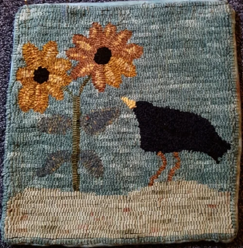 A primitive little crow checking out the sunflowers. Hooked by me.
