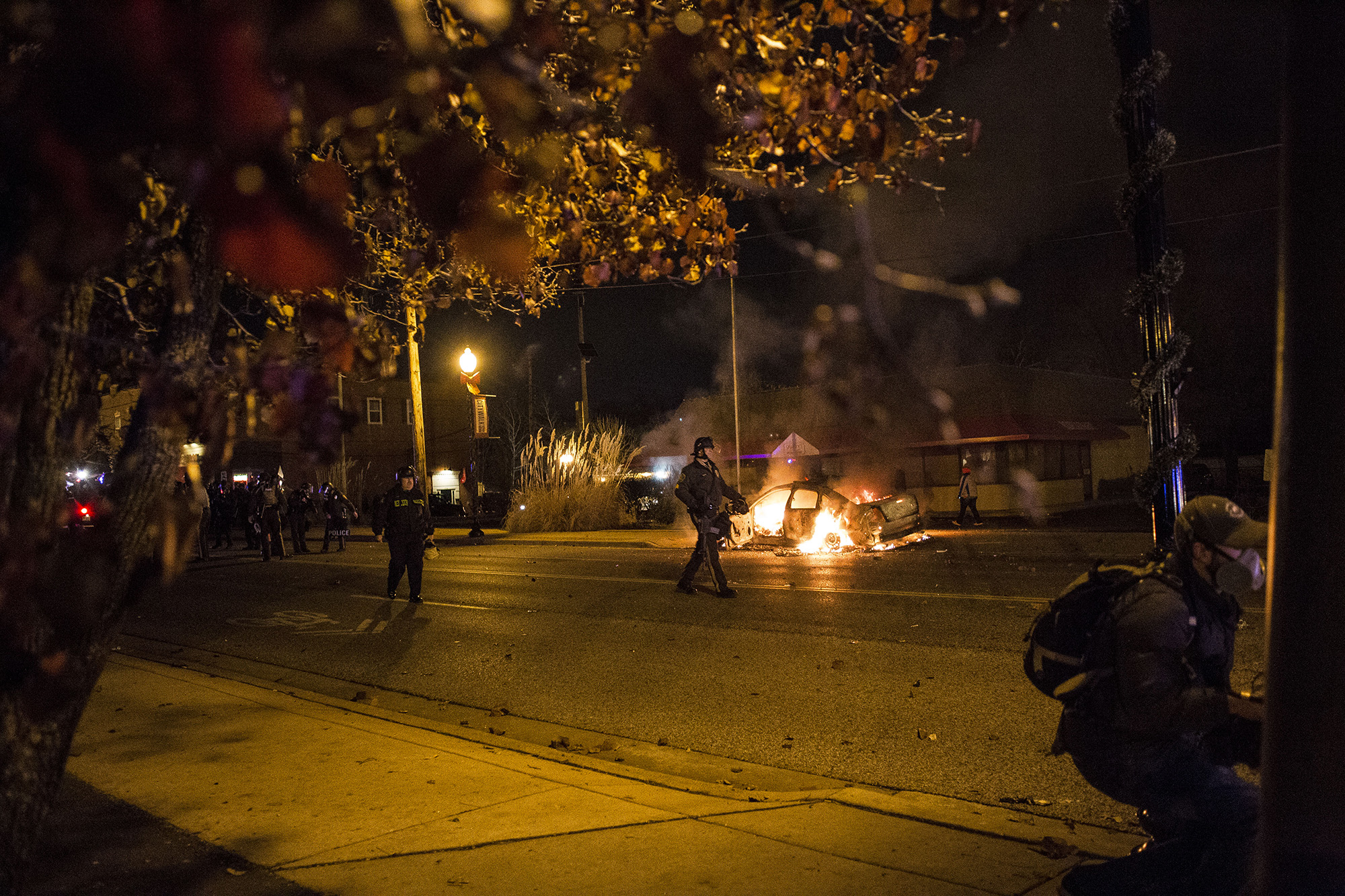  A police vehicle burns while police asks protesters to remain on the sidewalk on Nov. 24, 2014 in Ferguson, MO.&nbsp; 