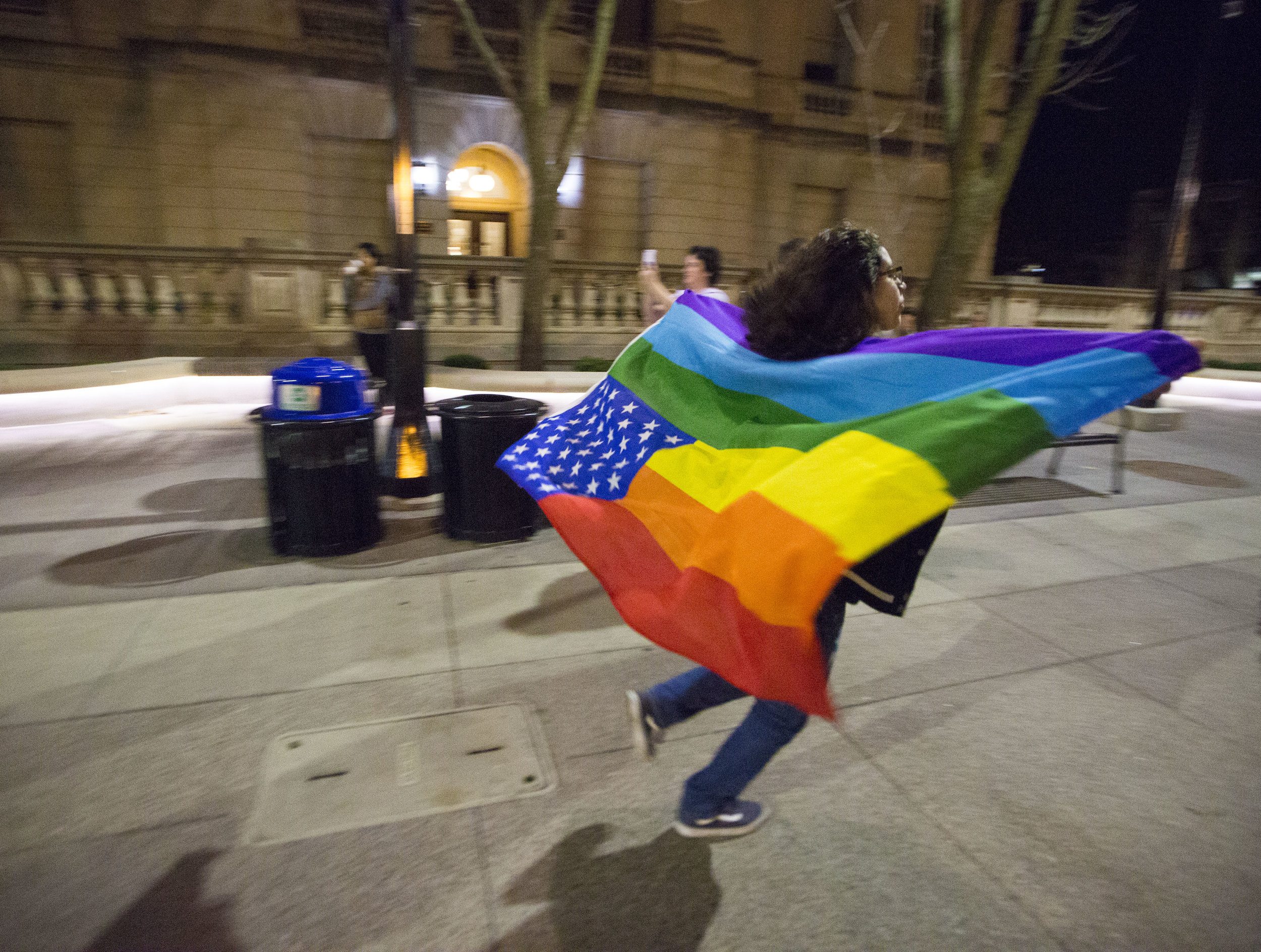  A UW-Madison student wears a rainbow flag and runs down Bascon Hill during an anti-Trump rally on Nov 10, 2016 in Madison, WI. 