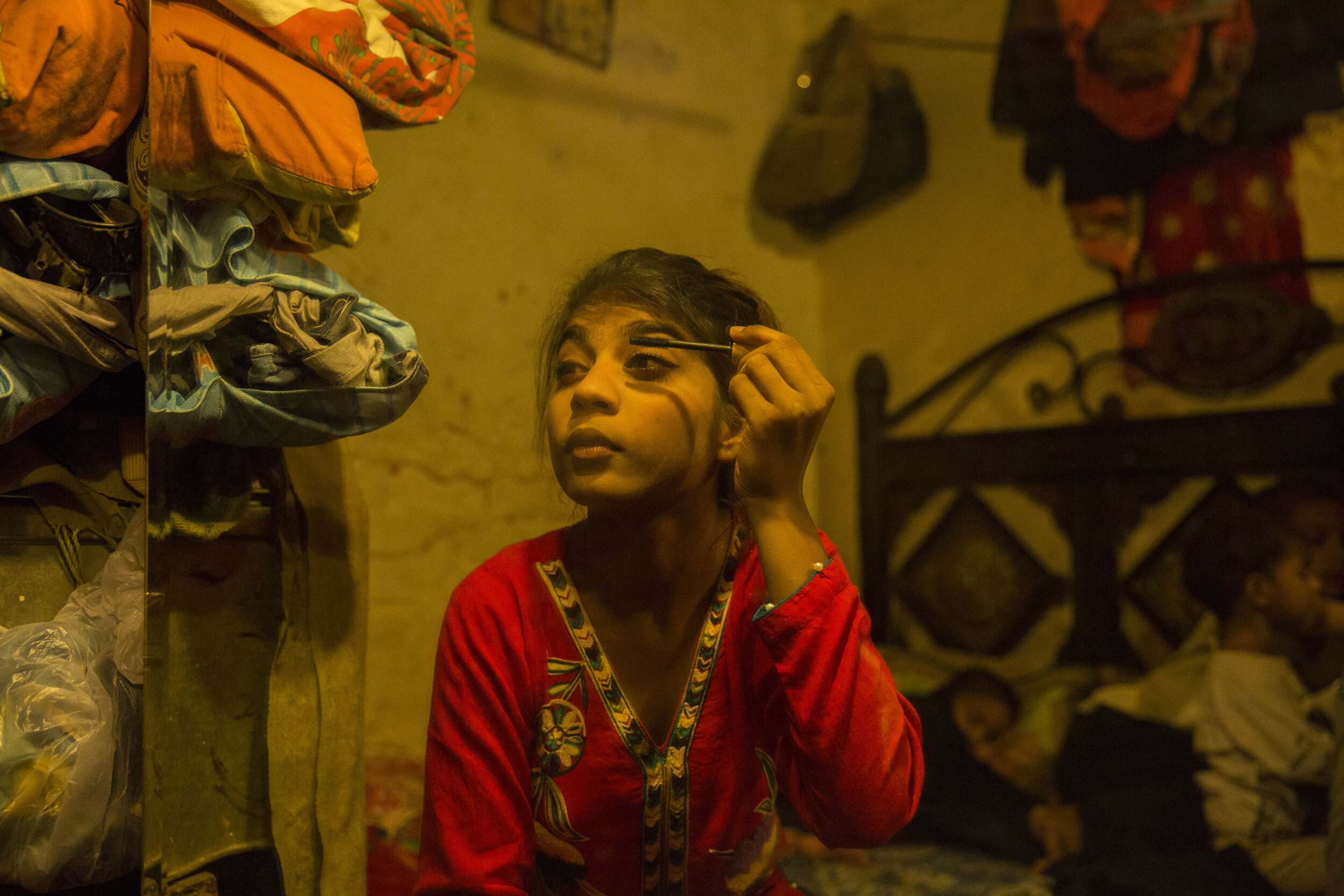  15-year-old Samantha puts on make-up as they get ready to go to the nearby park. 