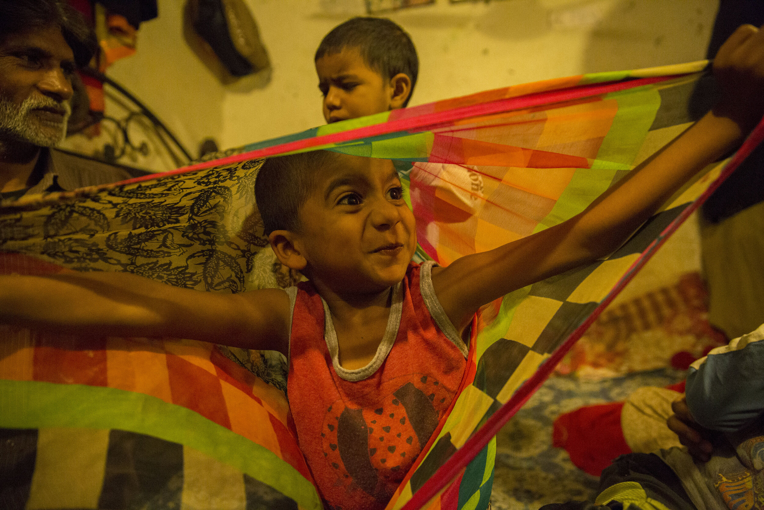  5-year-old Yushya plays with her mother's scarf (dupatta) as he entertains his family. 