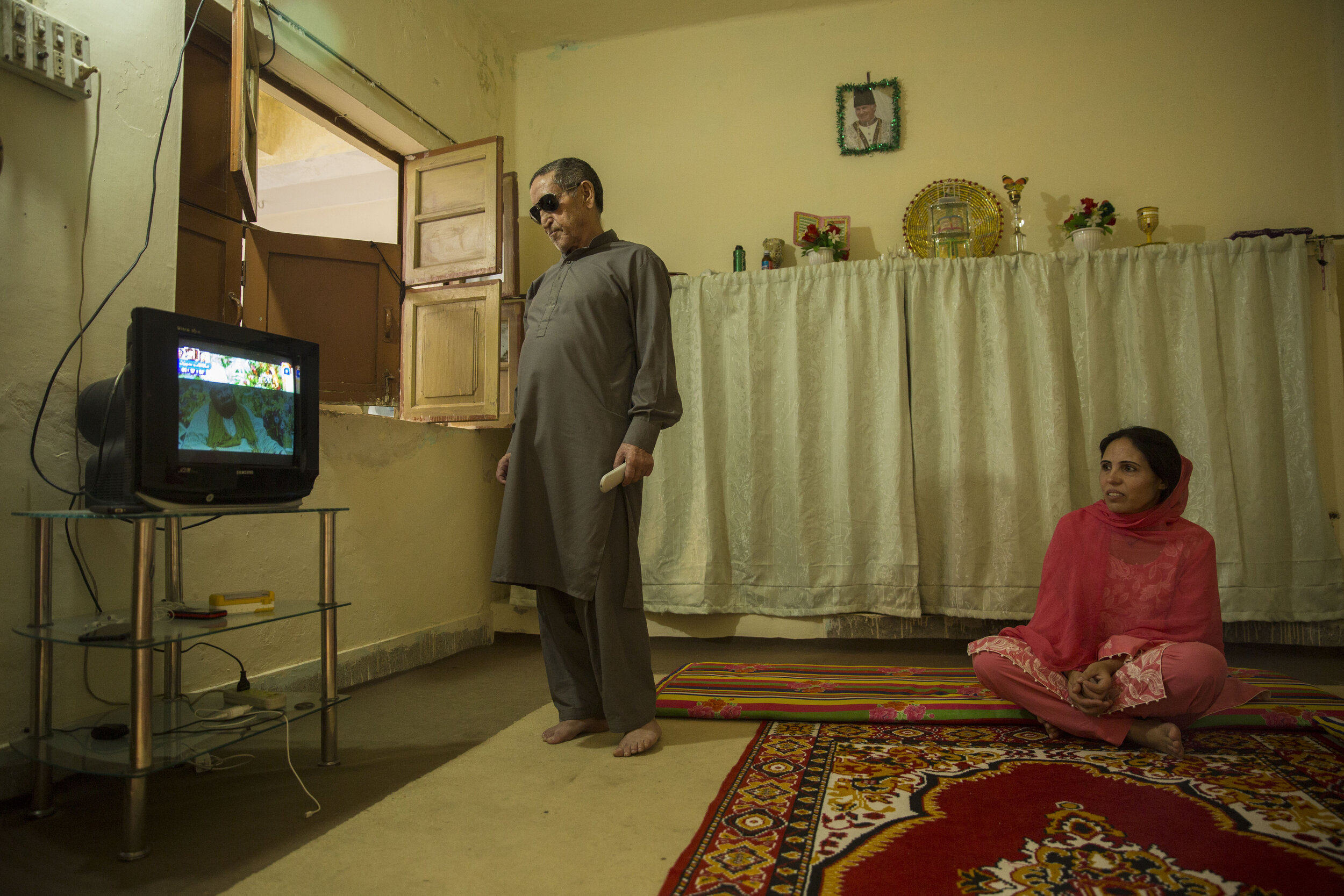  Nusrat Bibi, watches television with her father Dost Ali who has been ill for many years. 