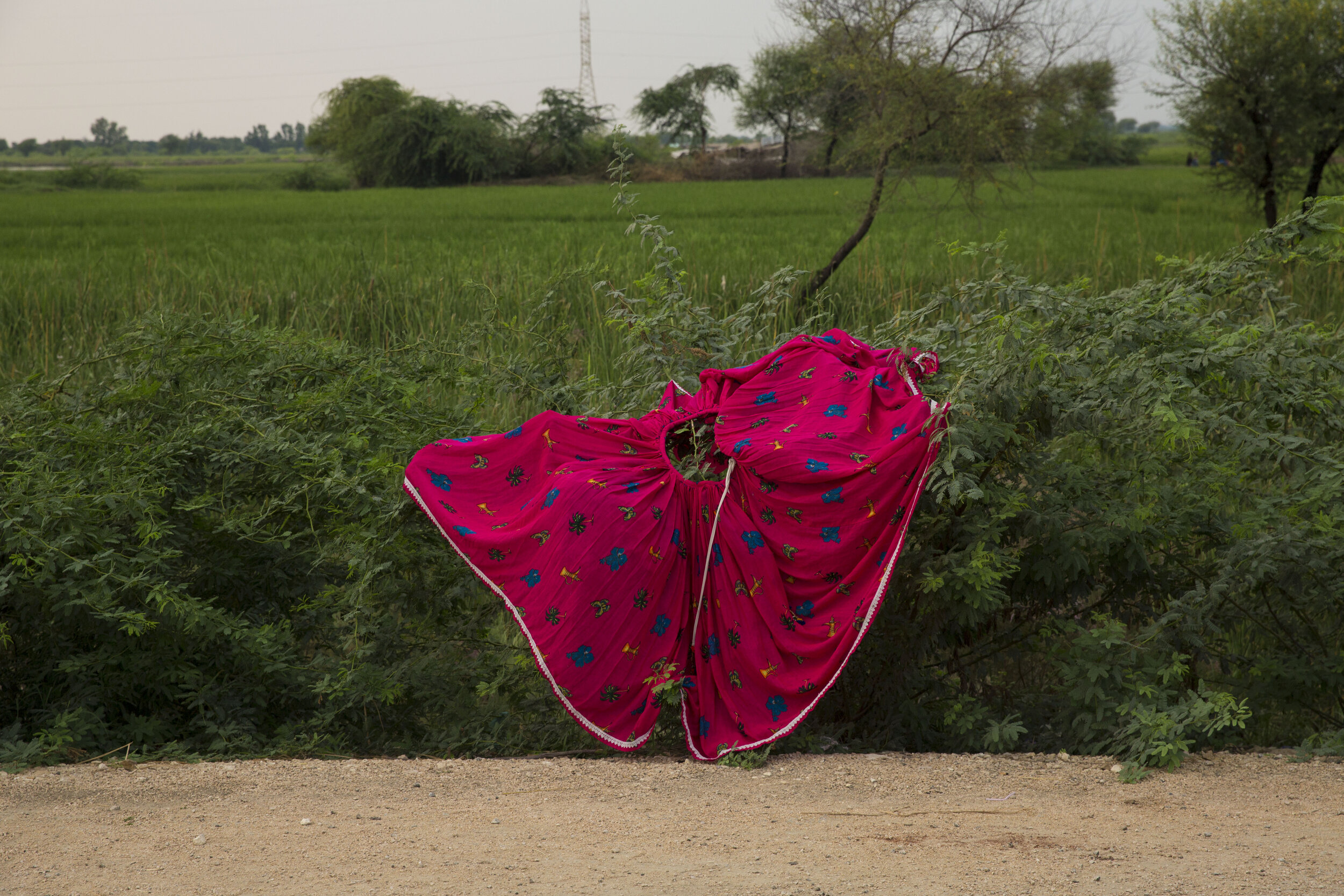  A woman dries her skirt amidst flash floods on the side of a highway as hundreds are camping out due to the recent floods. 