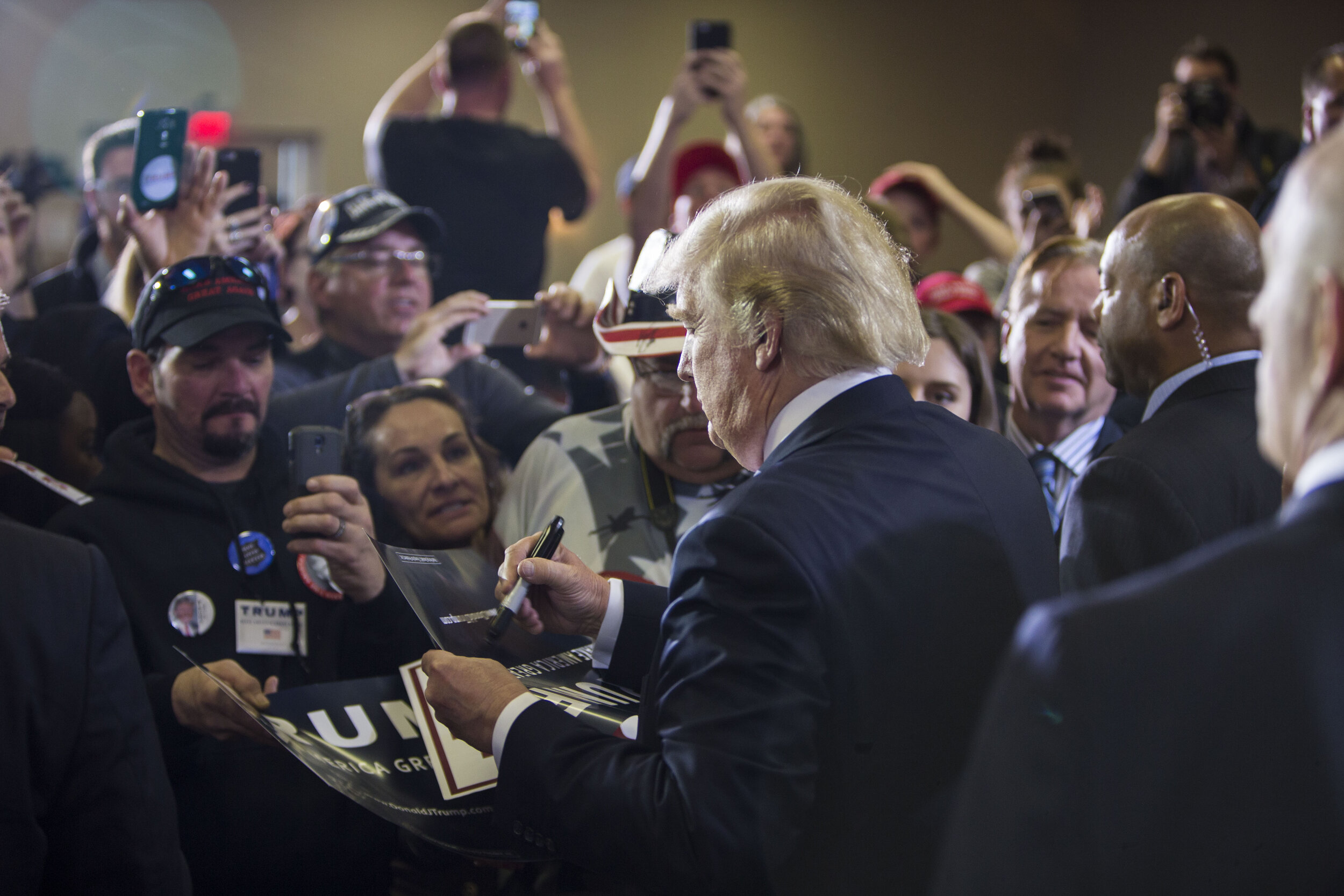  Donald Trump signs autographs for supporters after speaking at a campaign event. 