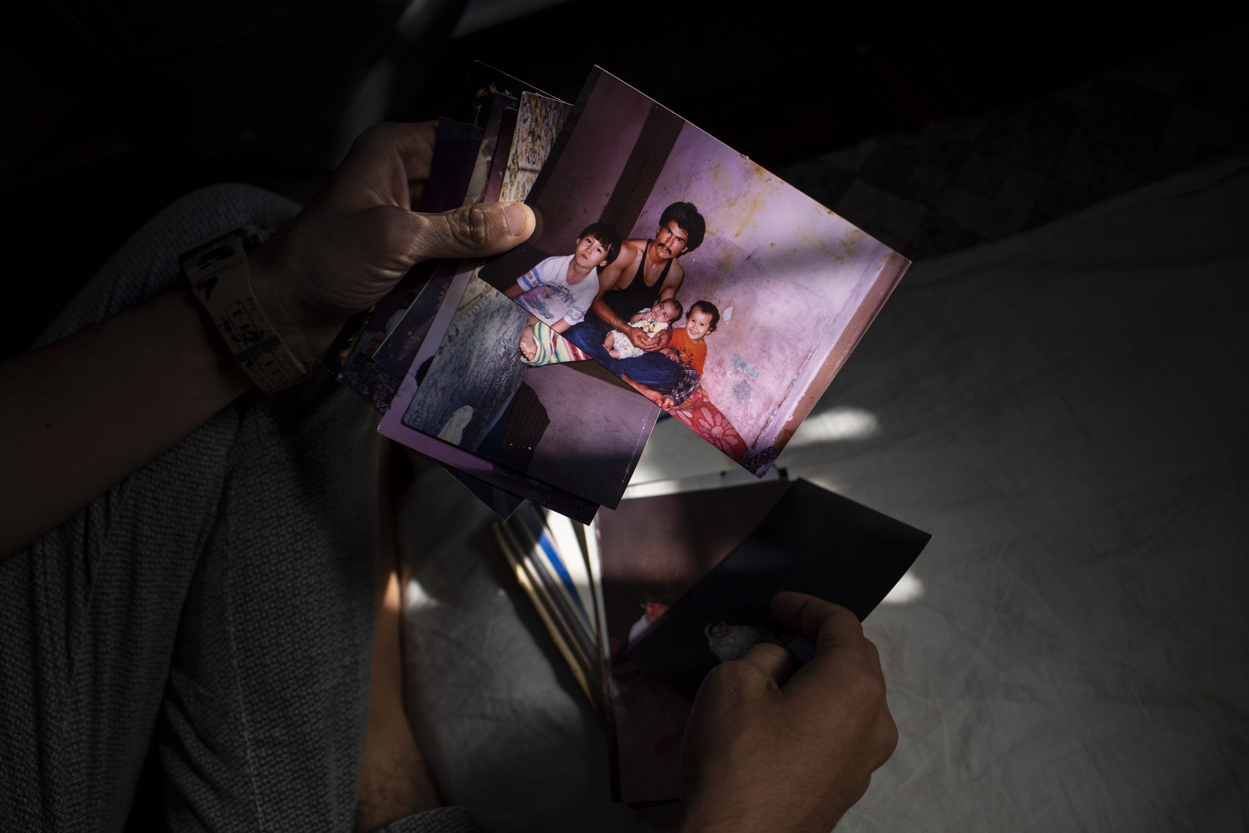  Madad Ali looks through old family photos of his father from Afghanistan. 