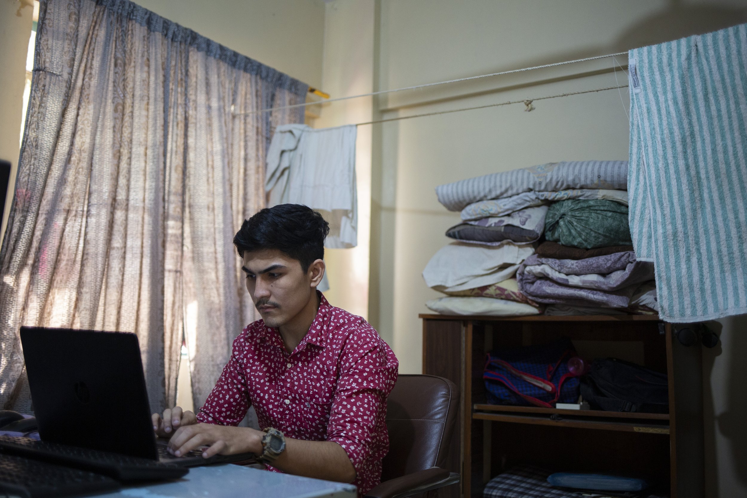  Madad Ali, a web developer, checking the computer to see if he has received any assignments. 