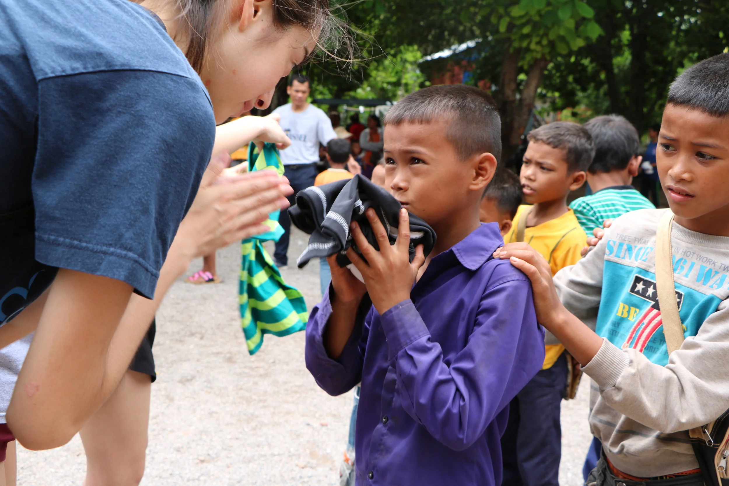 Miyu delivering clothes to children at the Kamping Puoy TASSEL School, 2016.