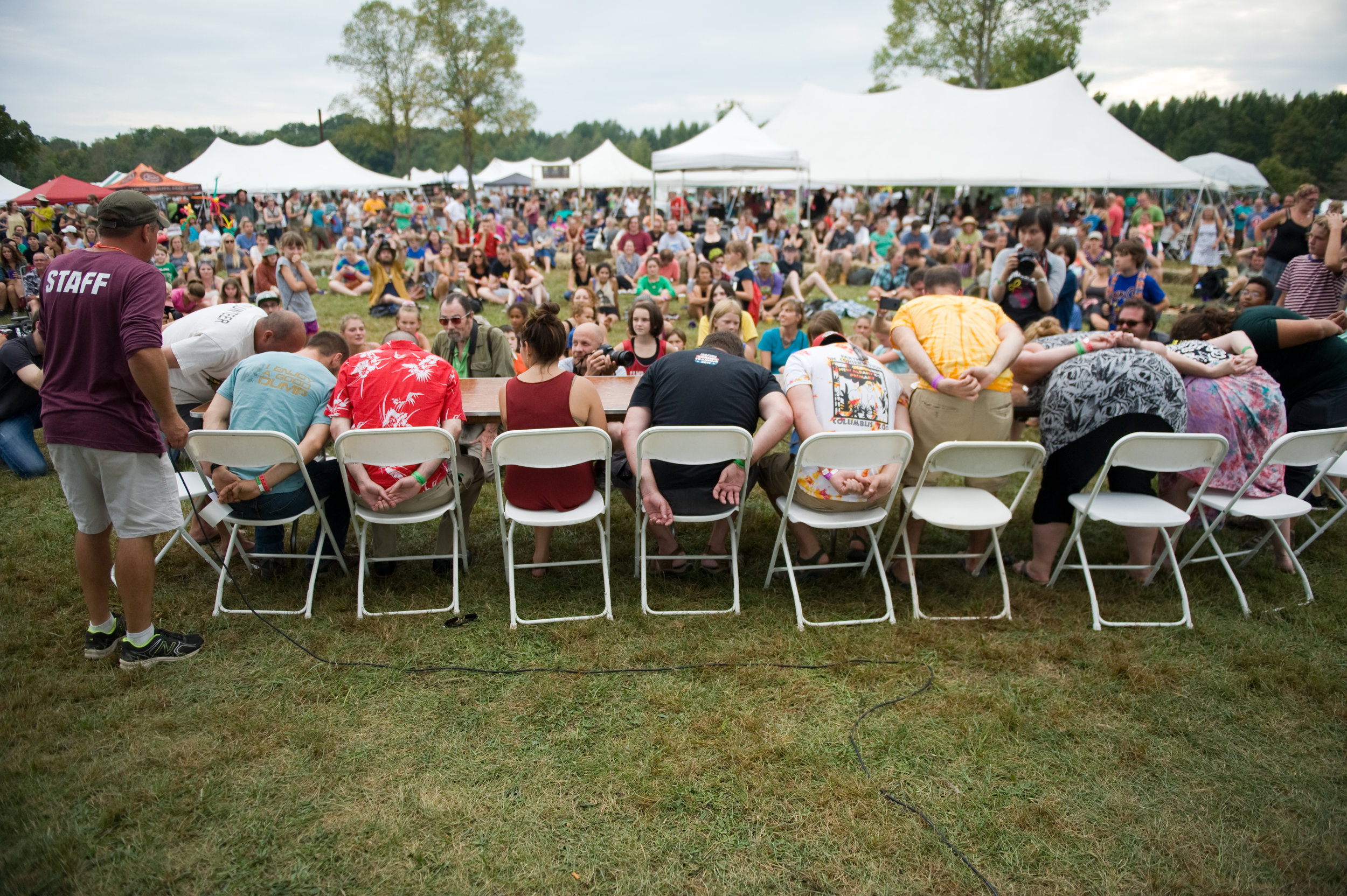 Festival attendees participating in a pawpaw eating contest, as the other fest goers cheer them on. Photo by Michelle Waters