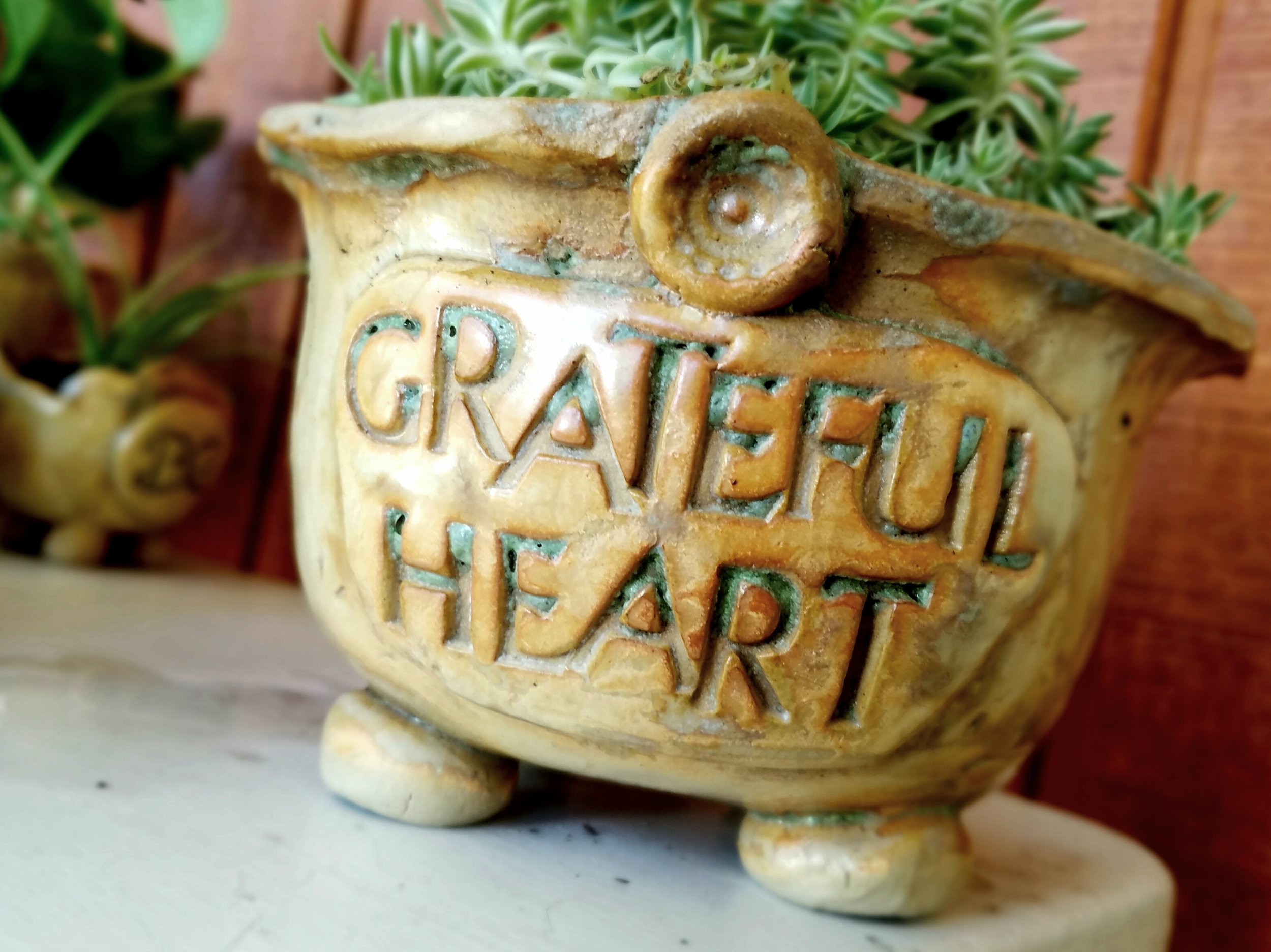 PLANTER FORMED AROUND A ANTIQUE GLASSWARE AND TEXTURED WITH VINTAGE LINEN AND BUTTON.