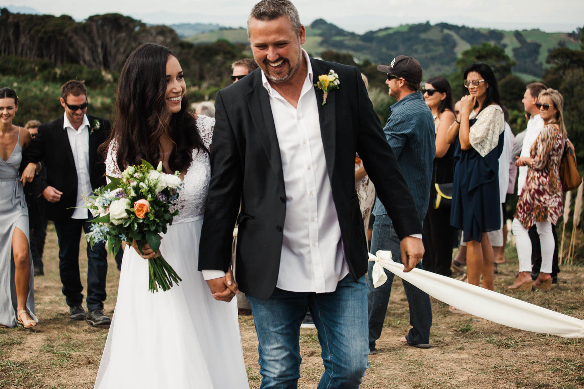 boho-bride-and-groom-walk-down-aisle-at-outdoor-wedding.jpg