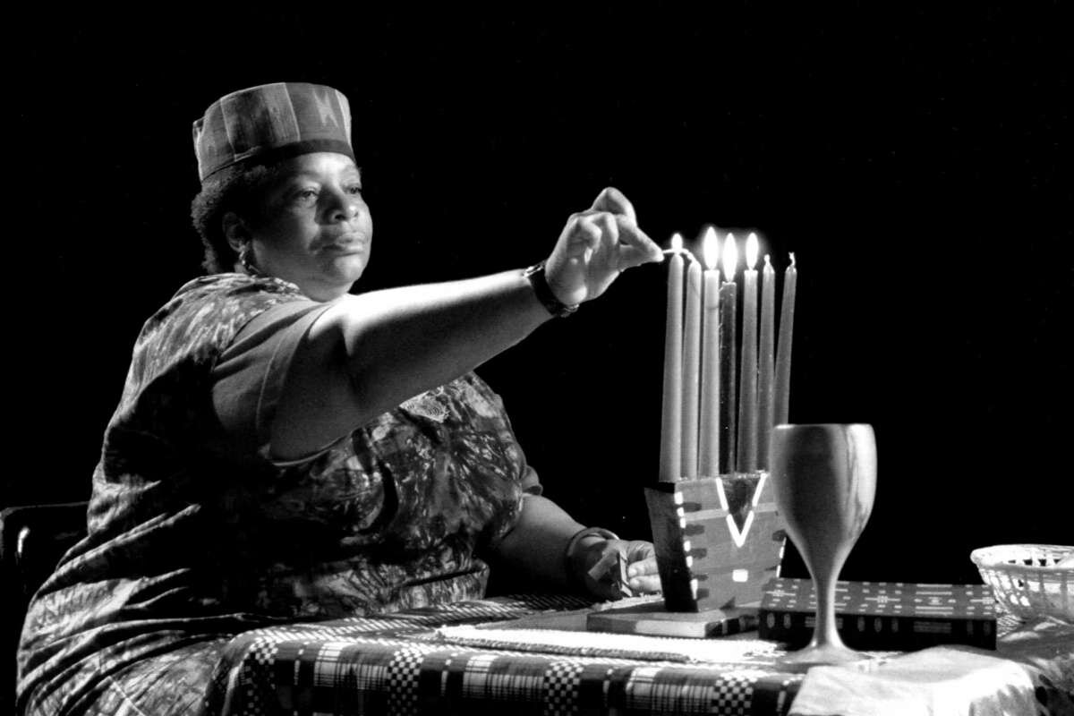 Fette Brown, a representative of the Bay Area Kwanzaa Committee, lights a candle as part of a Kwanzaa ceremony in 1992.