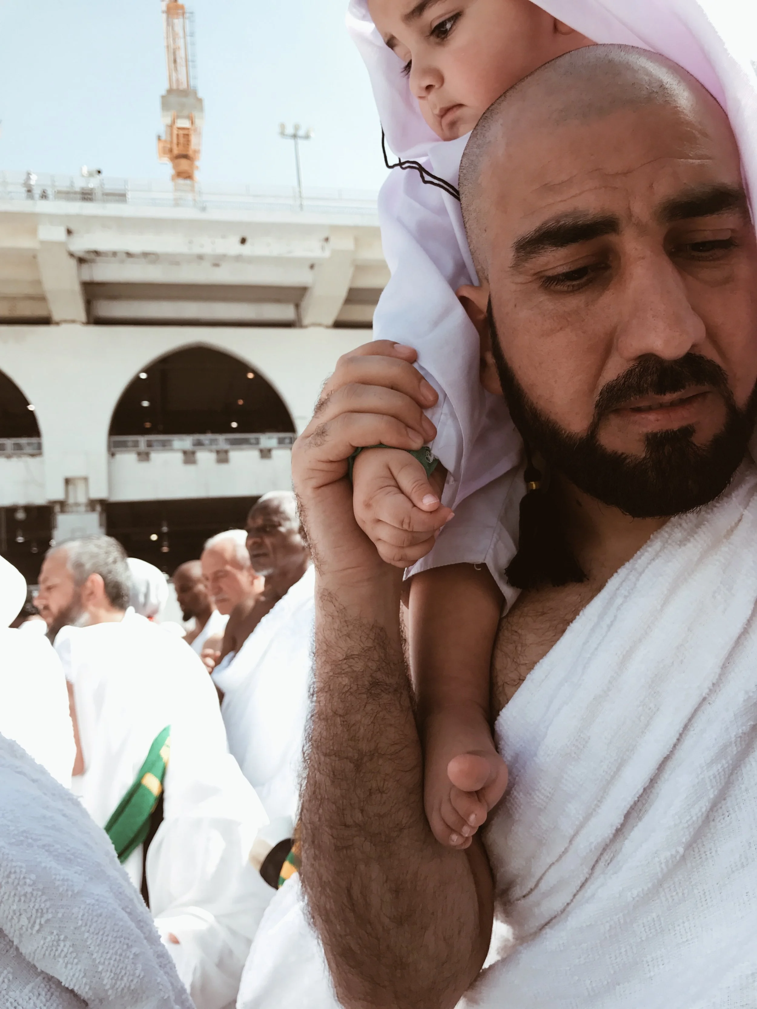  Parents/guardians carry their children while performing umrah. 