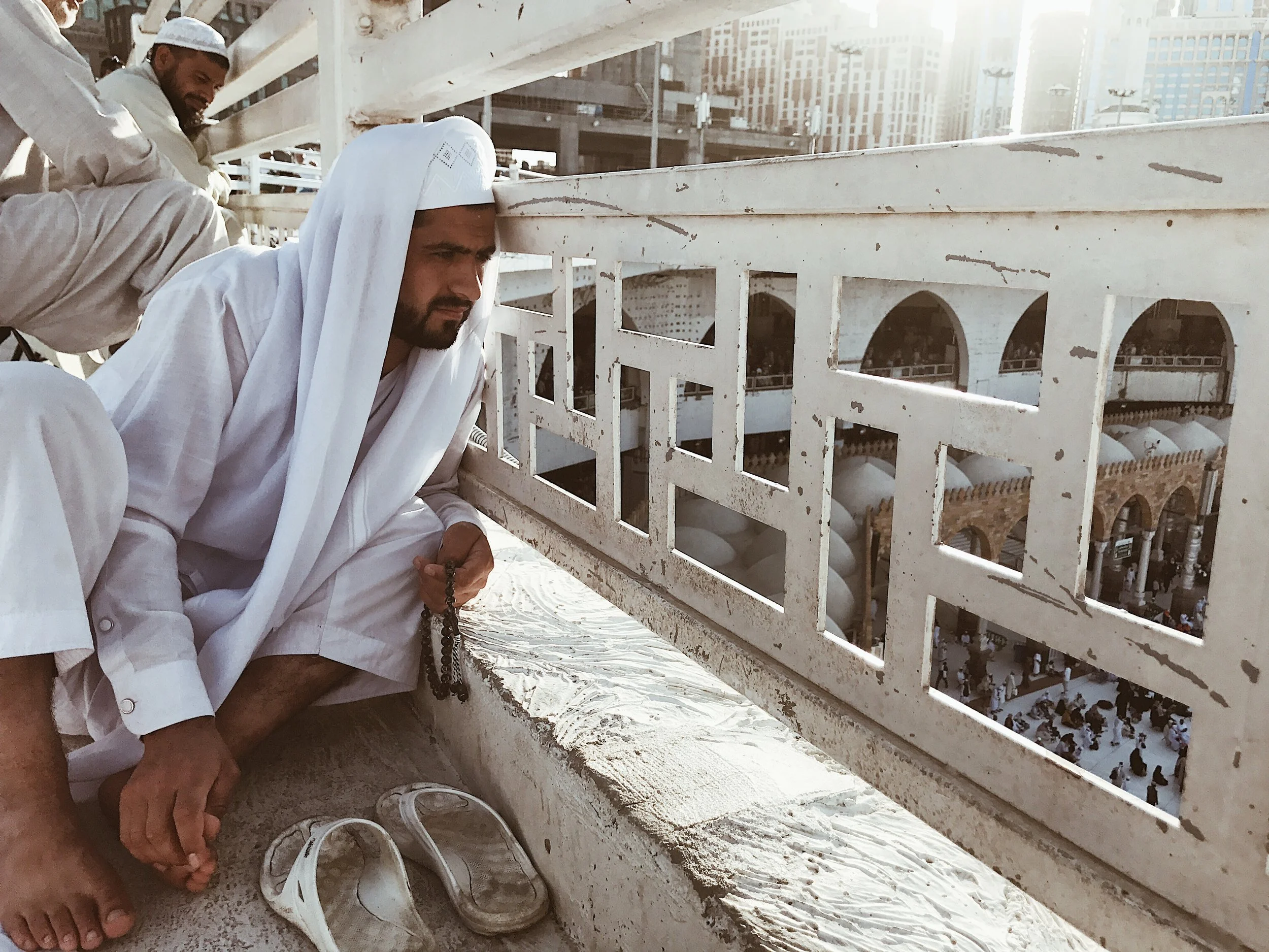  Pensive   A man watches pilgrims circling the Kaaba below while doing Dhikr (meaning remembrance). These are short phrases or prayers which are repeatedly recited silently or aloud. It is counted on a set of prayer beads called misbaha, which is lik