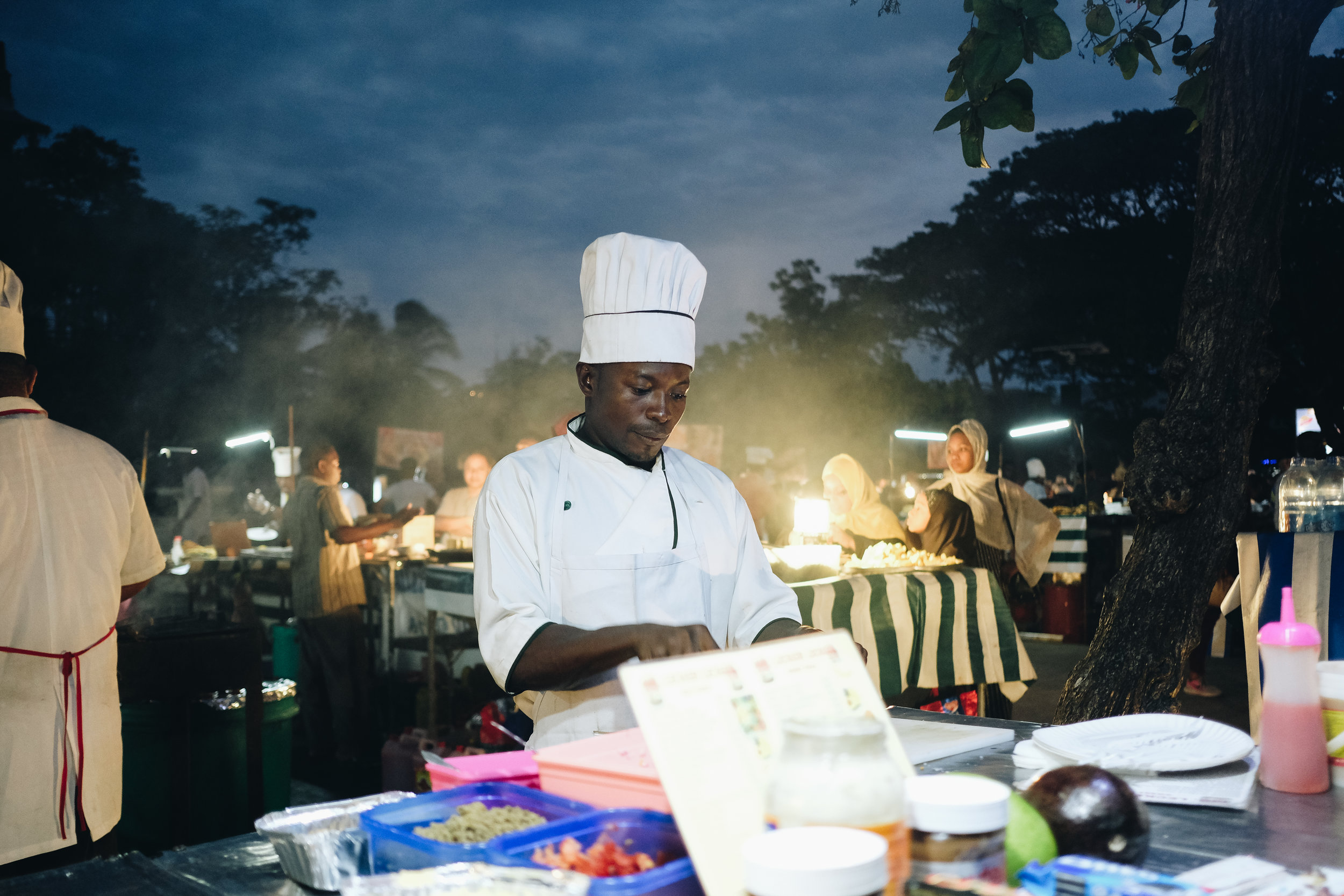 Smoke billows from grills where skewers of various seafoods were on display.