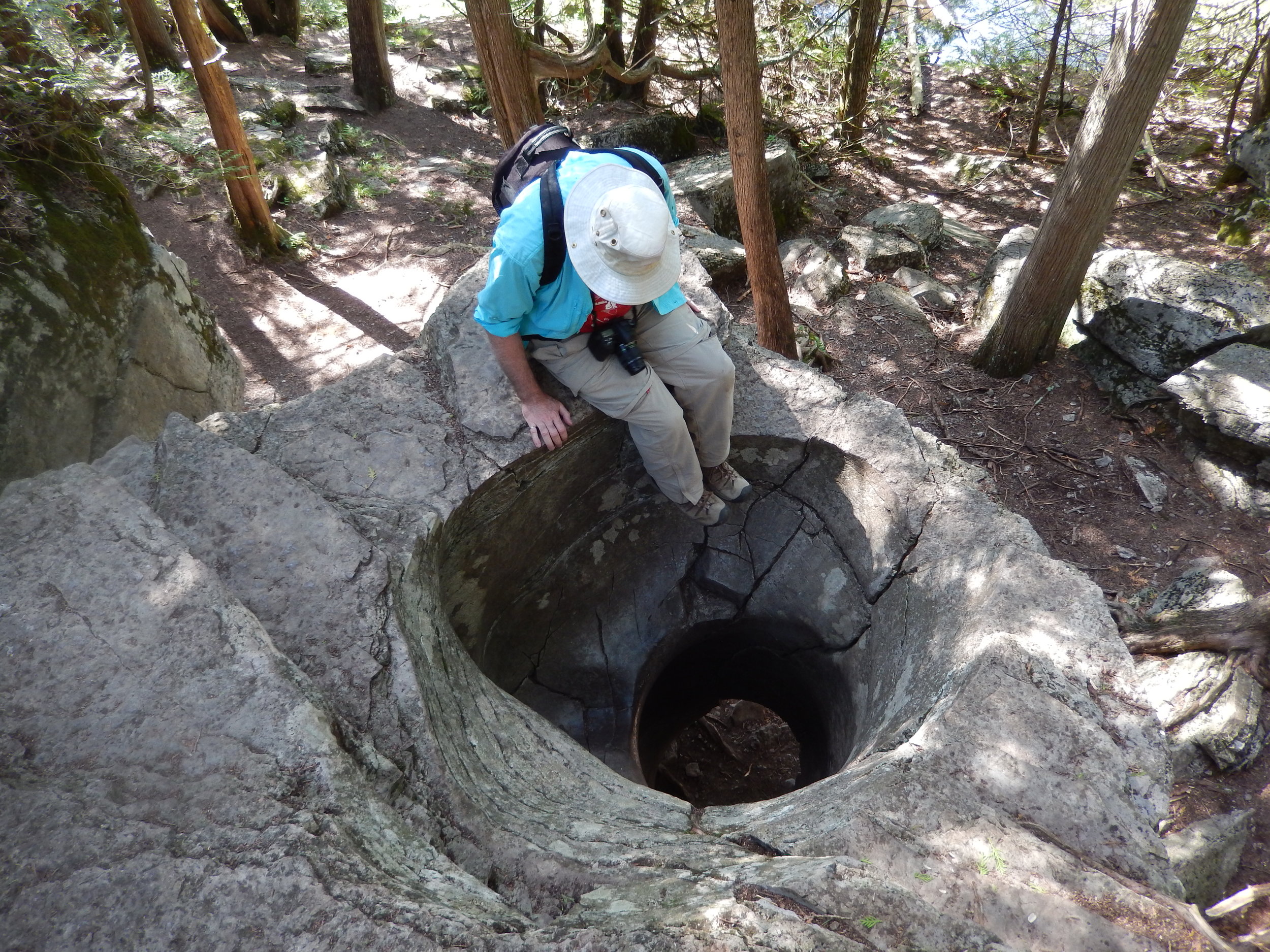 安迪Fyon坐在边缘的一个地质特性——一个洞——被称为壶穴。壶穴是在大约10000年前形成的,最后,最后一次大冰期时冲水卵石,钻入岩石。在th…