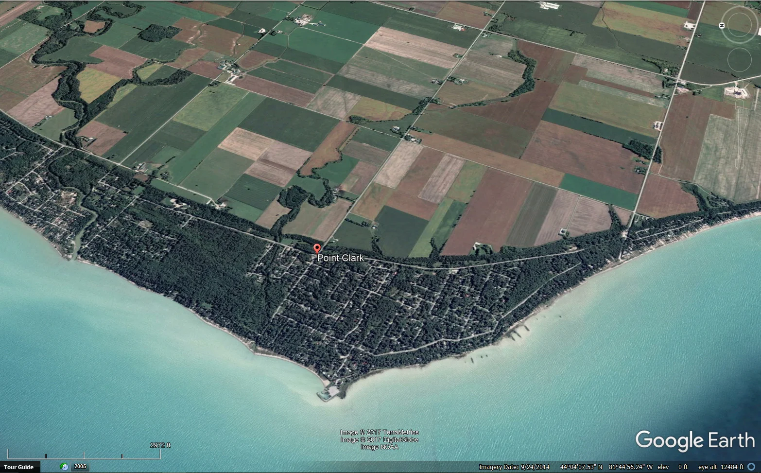 Figure 5: Google Earth image, looking east with Lake Huron in the foreground. The Lake Algonquin shoreline bluff is marked by the line that separates the green vegetated and developed cottage area from the farmland on the terrace above present day Lake Huron. The town of Point Clark sits on the old beach and other shoreline deposits between the present-day Lake Huron and the shoreline bluff.