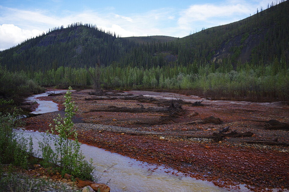 照片2:橙红色的铁染色,颜色或规模,河上的鹅卵石在红溪,育空地区,中部是矿物质,铁的结果形成了一个规模,或沉淀,在岩石表面。染色形式小溪的水反应的…