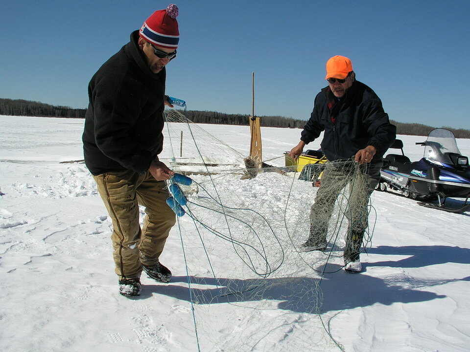 布拉德·耶斯诺(左)和安迪·耶斯诺(右)，他们都是伊巴梅通第一民族的乐队成员，在安大略省西北部的伊巴梅通湖捕鱼。raybet11捕鱼是第一民族传统土地利用方式的一部分。照片由Andy Fyon组成，我…