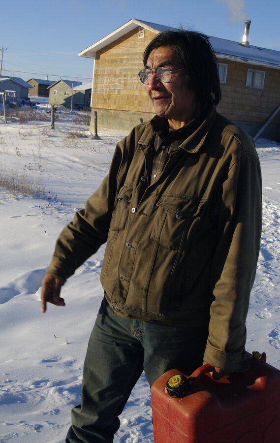 图4:Xavier Sagutch，也被称为“X先生”，在安大略省Eabametoong第一民族的家乡希望堡的街道上。raybet11尽管天气很冷，泽维尔还是满足于穿着他的牛仔夹克，没有戴手套，也没有戴帽子。他拿着一个塑料气体容器。
