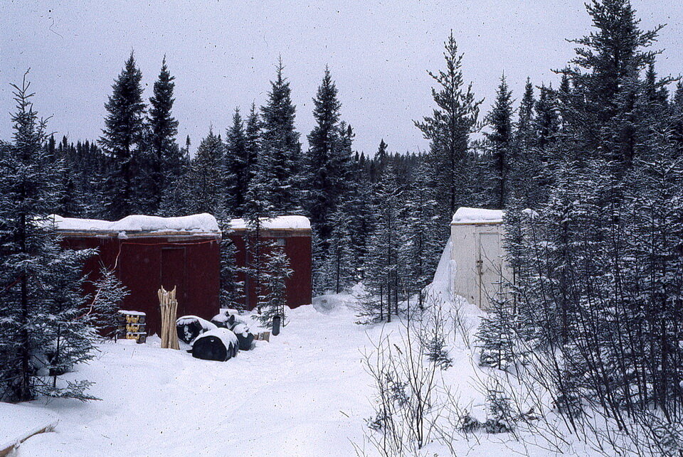 照片2:红色的“盒子”是预制结构,我们用作冬季布什阵营。他们大约30英尺长,宽15英尺。他们是由燃油加热炉子。他们更舒适比帐篷的时候-40 c。他们有一个缺点。他们没有一个室内卫生间只这个营地位于萨宾湖地区,莎凡特湖,南部安大略省1977年。raybet11右边的白色建筑包含一台发电机。1977年安迪•Fyon形象。