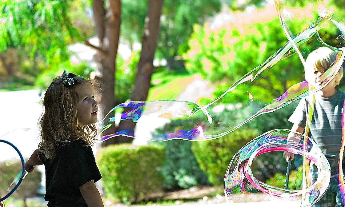 girl and boy with buble outside cropped.jpg