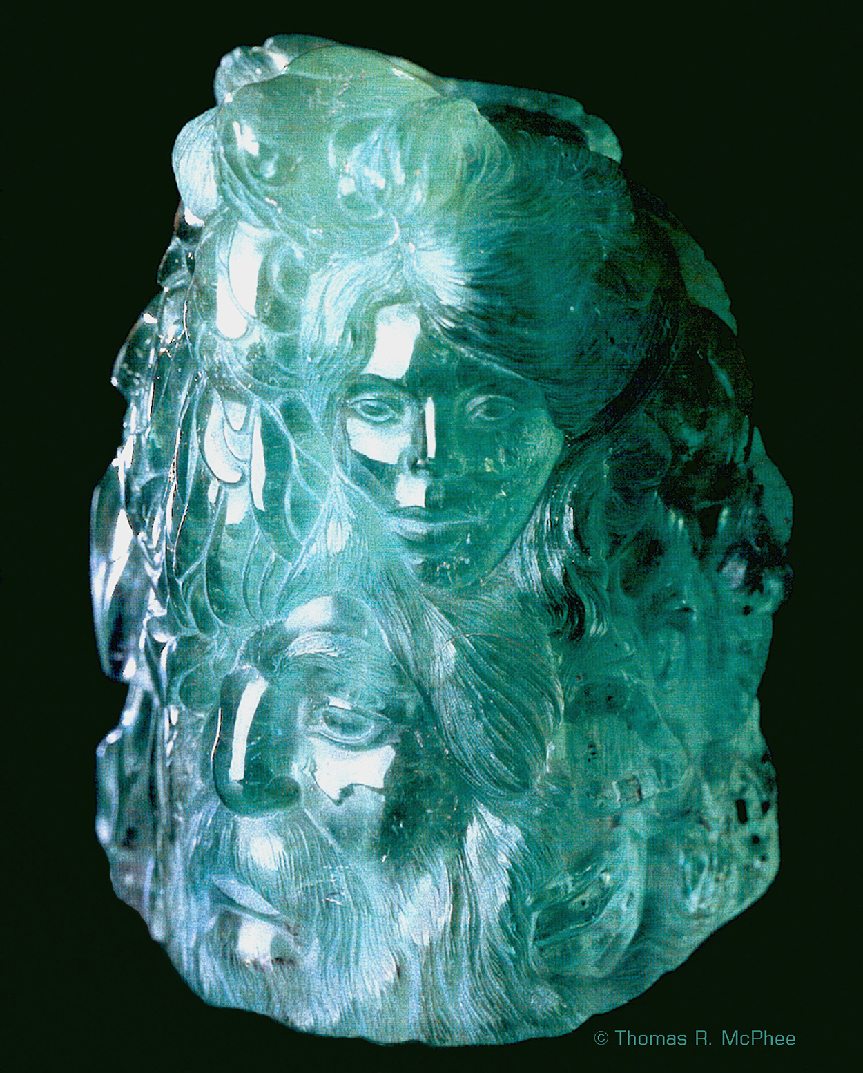  Thomas R. McPhee spent more than six months designing and carving the Emerald Crystal from the famous Muzo Mine in Colombia.&nbsp; The main body of the stone is carved in high relief and contains intertwined figures representing the various aspects 