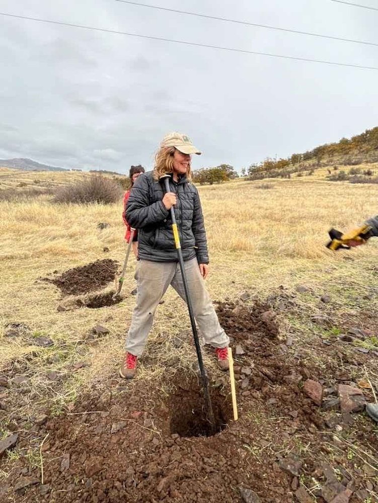 Person gauging depth of a fence post hole