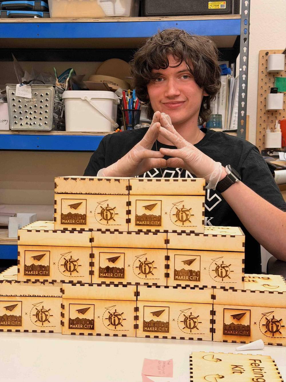 Intern behind a tower of felting kits