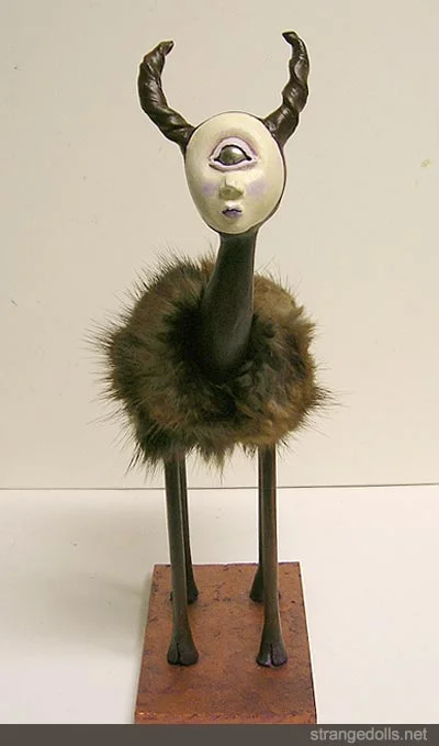 The Cyclops is 11.5 inches tall. The Cyclops knows it is a special breed. The coat is real fox fur. The legs and base are made of wood.