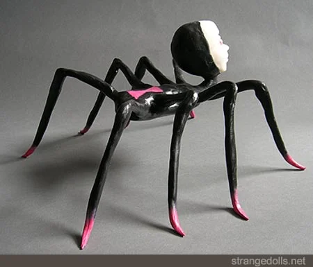 The spider doll is made from apoxie sculpt and polymer clay. She is hand painted black and pink. She is 12 inches wide by 12 inches tall. She was made in 2013.