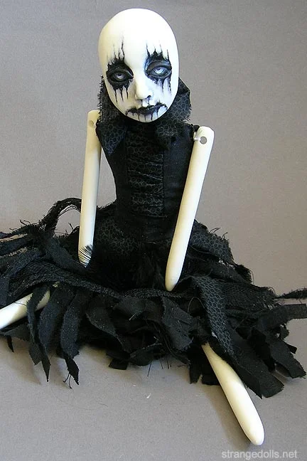 The corpse paint dolls were a series of dolls I created in 2014. They are characterized by ghoulishly painted faces, torn black fabric dresses with a ruched bodice and collar. The clothing is hand sewn. The bodies are made from sculpts that are cast in resin and sewn to a cloth body. They are 13 inches tall. 