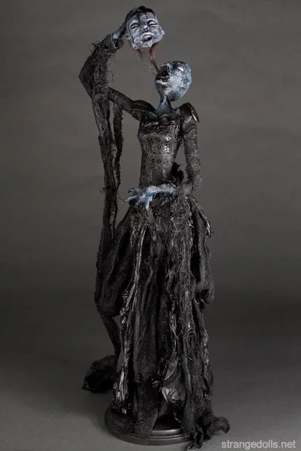 They stand 28 inches tall and are mounted to a wood base. The body is hand sculpted using a mixture of air dry clay. The clothing is fashioned from recycled materials: crab pincers, snail feet, chain, plaster, cheesecloth... and Lord Gallow's hair. These Soul Eaters were made in 2014.