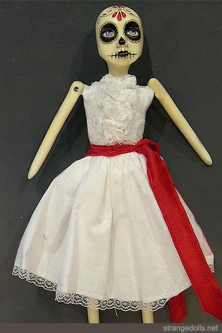 The head and appendages are resin, cast from an original sculpt and mold I designed. The body is handsewn using using 100% cotton and stuffed with batting. This gives these smaller dolls a 'rag doll' aesthetic. Her face has been hand painted in the traditional Día de Muertos style using acrylic paint. The doll is 12 inches tall. I have made numerous versions of these little skeletal rag dolls over the years.