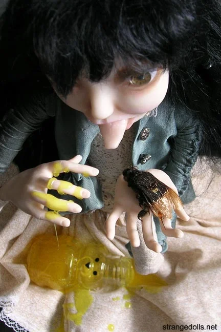 She is in a sitting position, attached to a wood base. She is 12.5 inches tall and 10 inches wide. She has an overturned honey bear in her lap with resin honey pouring out. She is holding a real honey bee (freeze dried from Tanzania). Her hair is mohair and her clothing has been hand sewn onto her, they contain vintage lace and buttons. She was made in 2013.