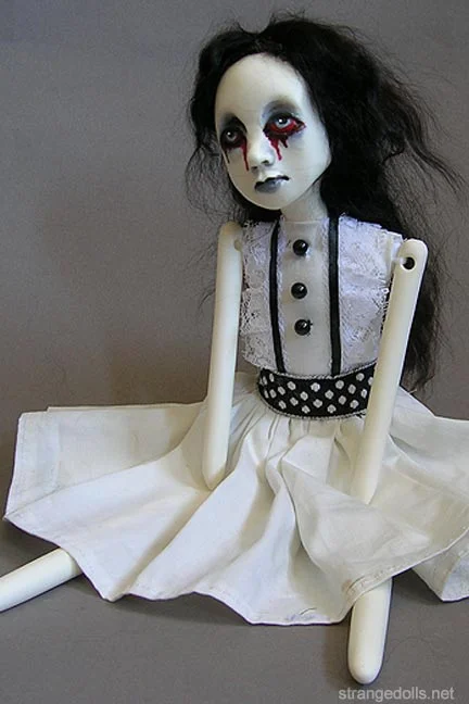This series of dolls are 12 inches tall. They are made of Urethane resin. Their clothing is white and lacy to reflect their purity. Their hair is black mohair.