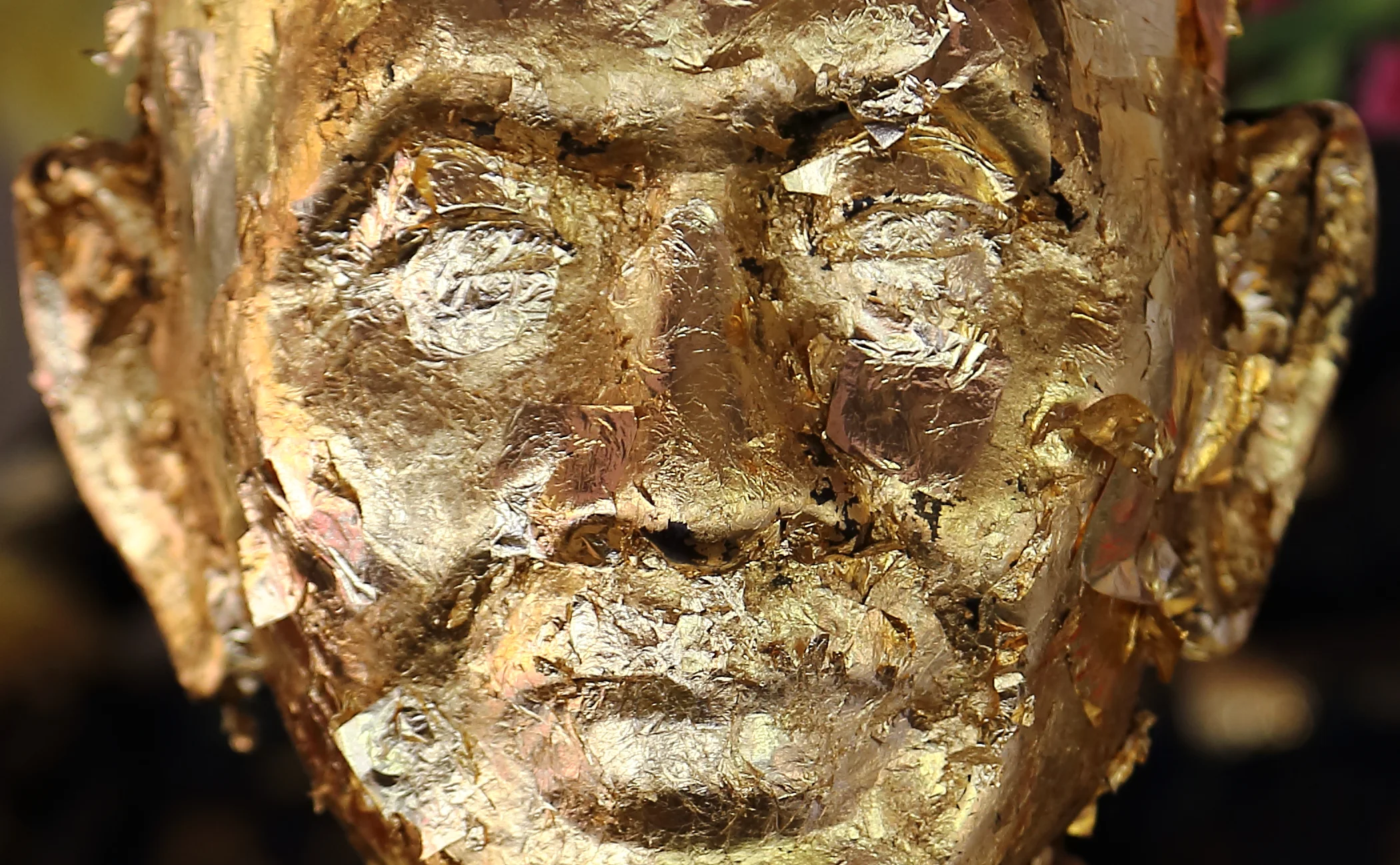 Thick accumulations of gold leaf on a statue of a beloved abbot