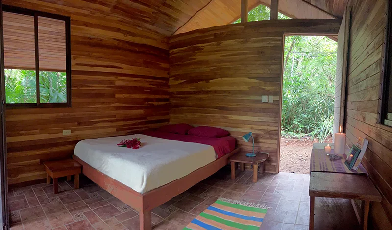 These open-air, screened in bungalows are about 2 minutes walking distance from the village center. The bungalows merge comfort and organic qualities by providing a completely screened in option built from wood in the pristine PachaMama forest. Furnished with a standard queen-size bed, all bungalows are ideal for up to two adults. Sliding screen doors separate the main space from the balcony to make this accommodation completely bug-proof. Ceramic floors, wooden walls and a covered balcony give a very cozy feeling overlooking the forest. Standard bungalows measure 14 sq meters and each have private hot showers and are located in the vicinity of shared compost toilets. Bungalow Package: Early Bird $1020 / Regular $1050 Shared Bungalow: Early Bird $1830 / Regular $1890