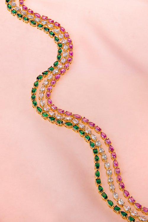 Gold-Triple-Shaped-Necklace-On+Silk-Rectangle.webp
