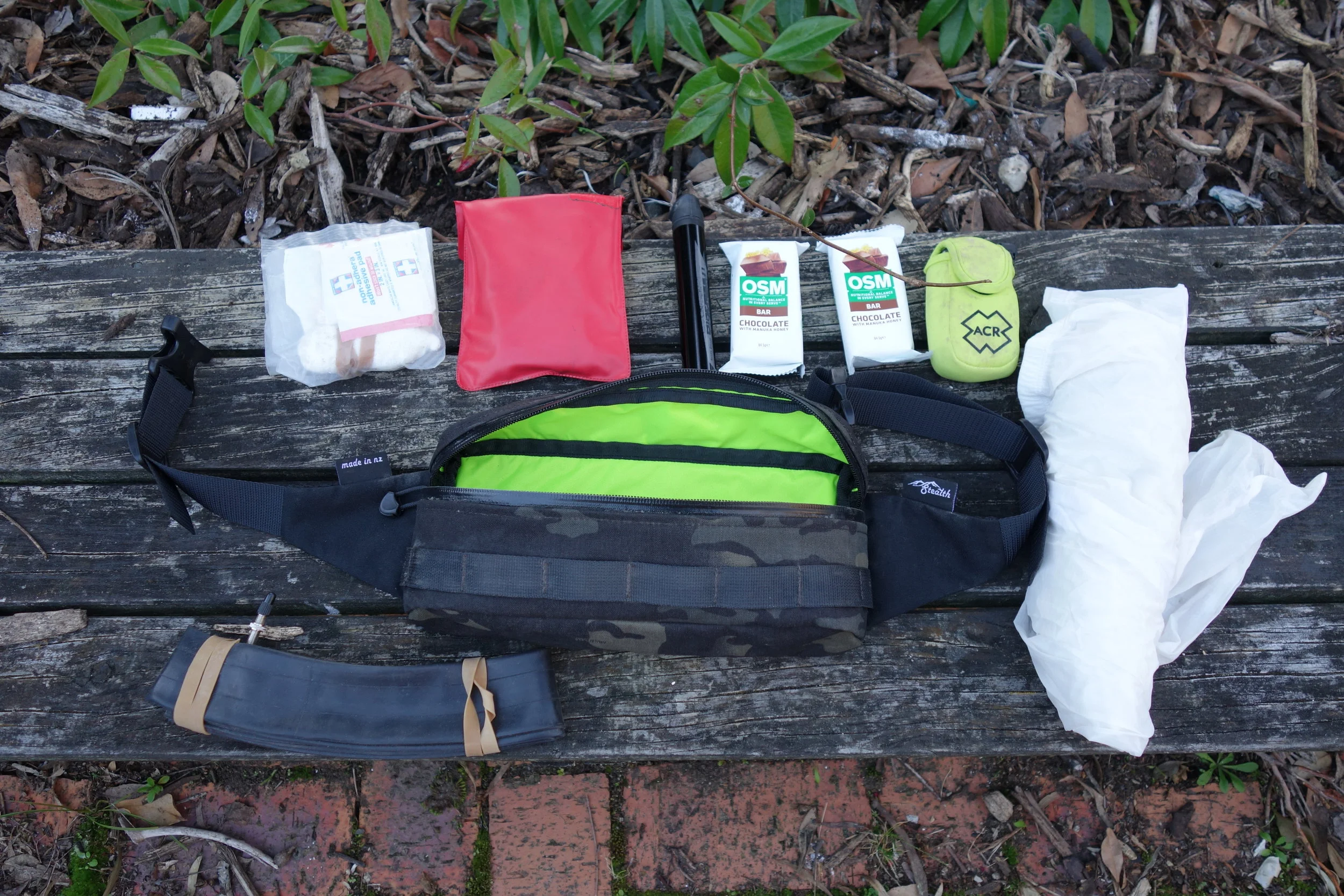 The bonus of one simple compartment is that you can pack everything in so much easier. There is a mesh divider across the bag so you can have a front and rear separation if you desire. The webbing strap is there so you can attach items to the outside. I use an elastic cord to attach knee pads and discarded clothing. It also has a nice soft wicking material that sits against your back.