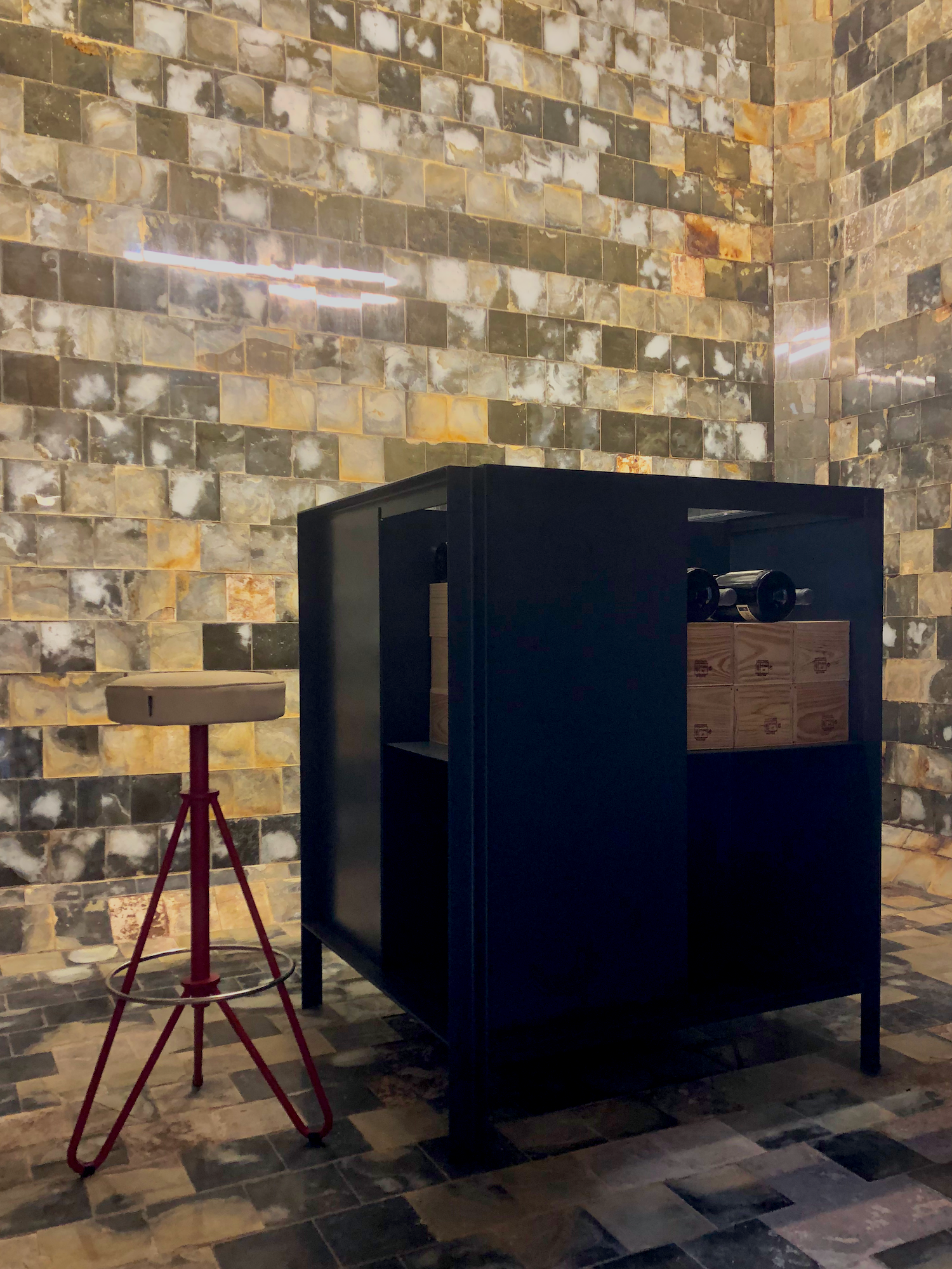A tile-paneled aging vat repurposed into a private tasting cubicle.