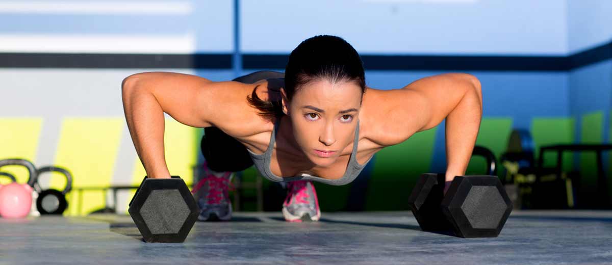 Girl used dumbbell as equipment of pushup.