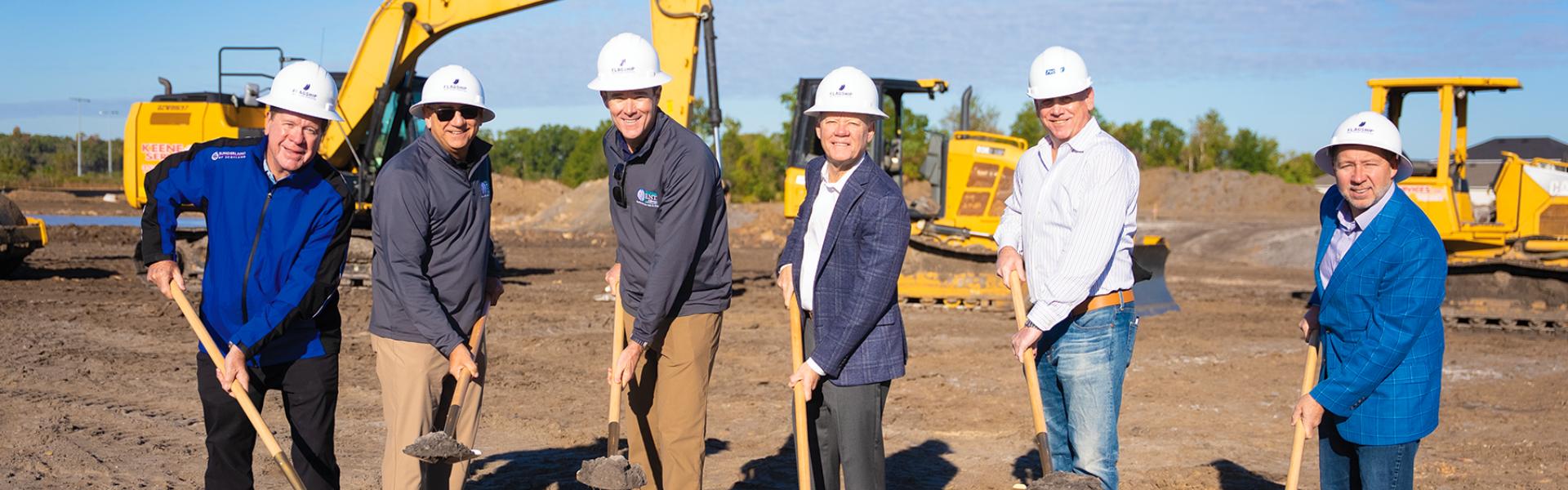 team with shovels breaking ground