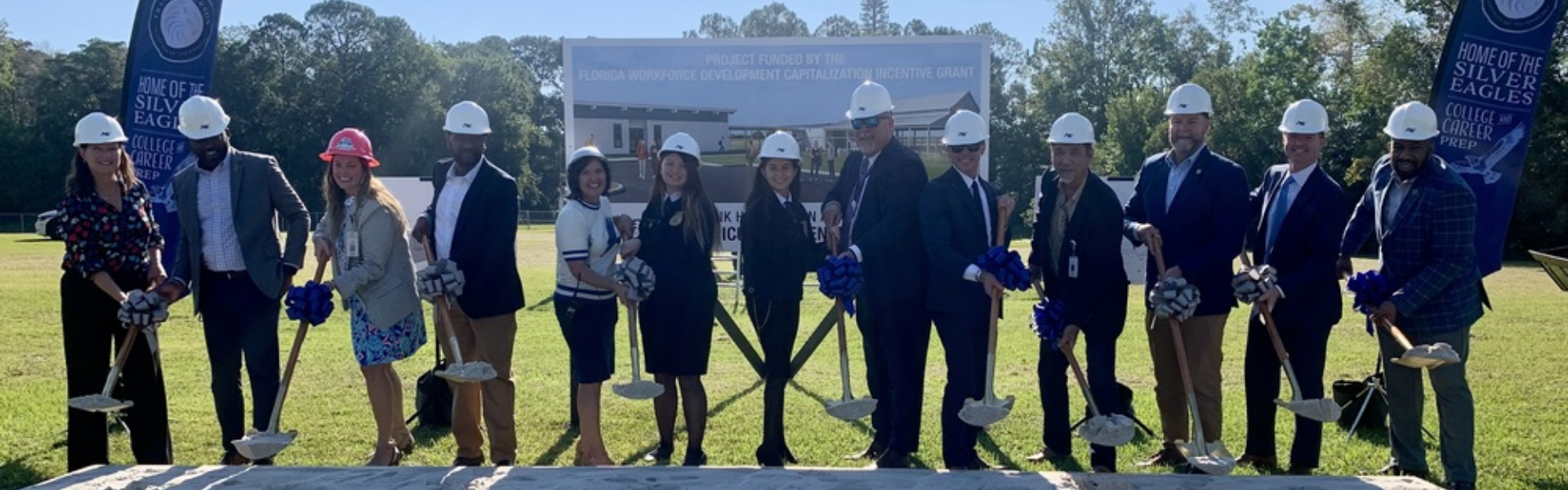 team with shovels breaking ground
