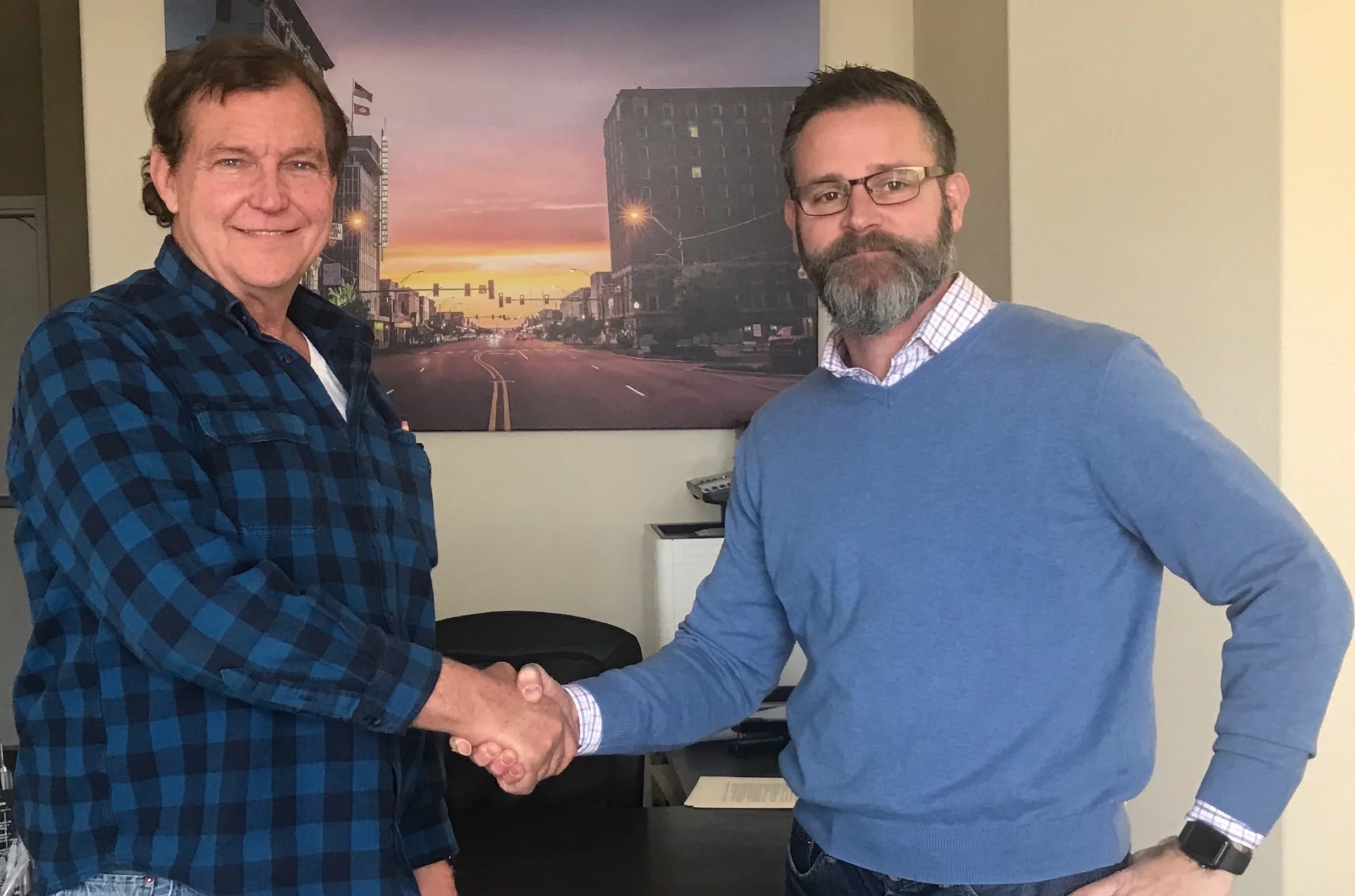 New owner Rick Ralston (R) shakes hands with seller Ed Boyd.