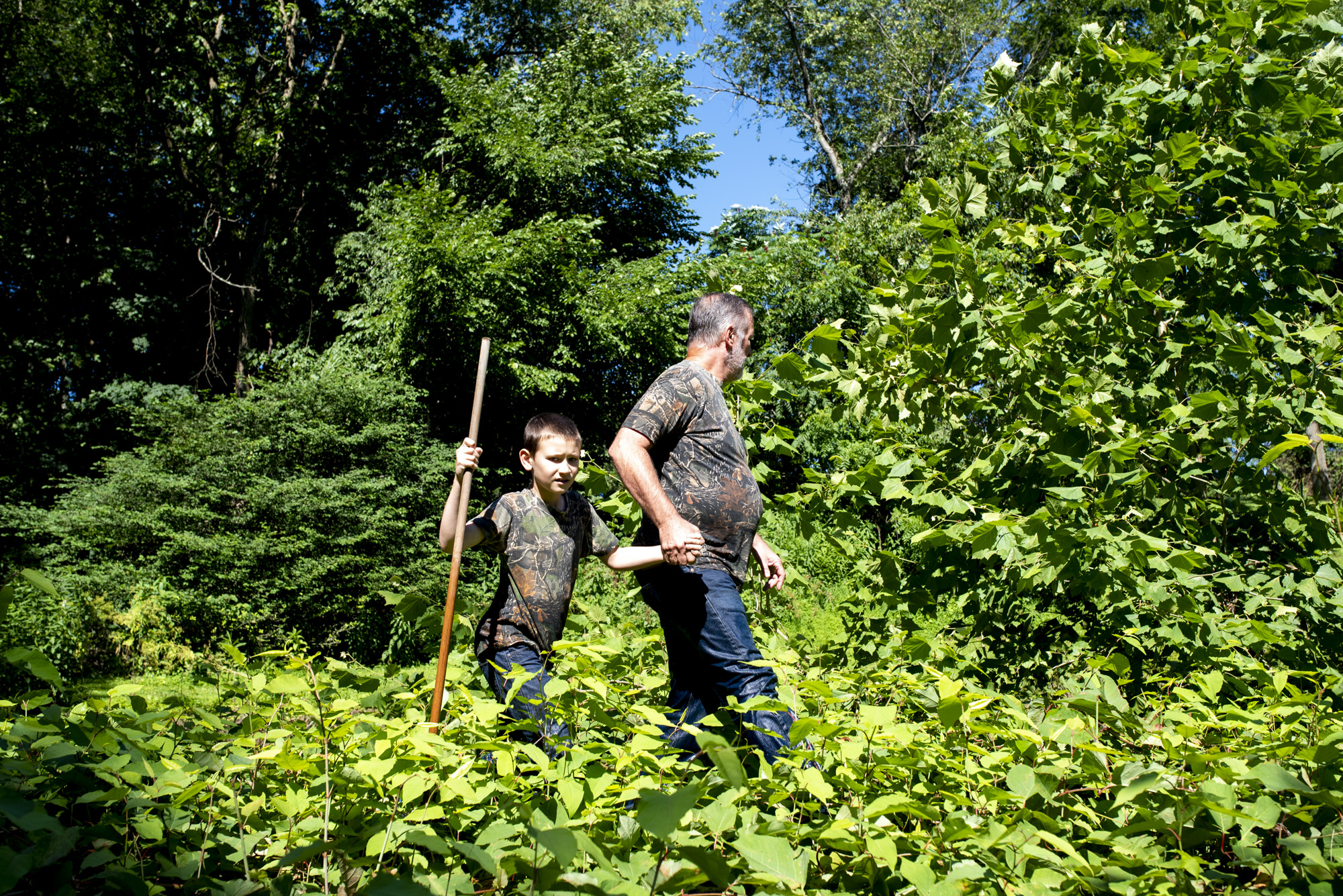  Vince Clemens and his son, Adyn Clemens, of North Huntingdon, walk through the brush to get to Brush Creek in Penn, where they hunt for snapping turtles on July 7, 2018. 